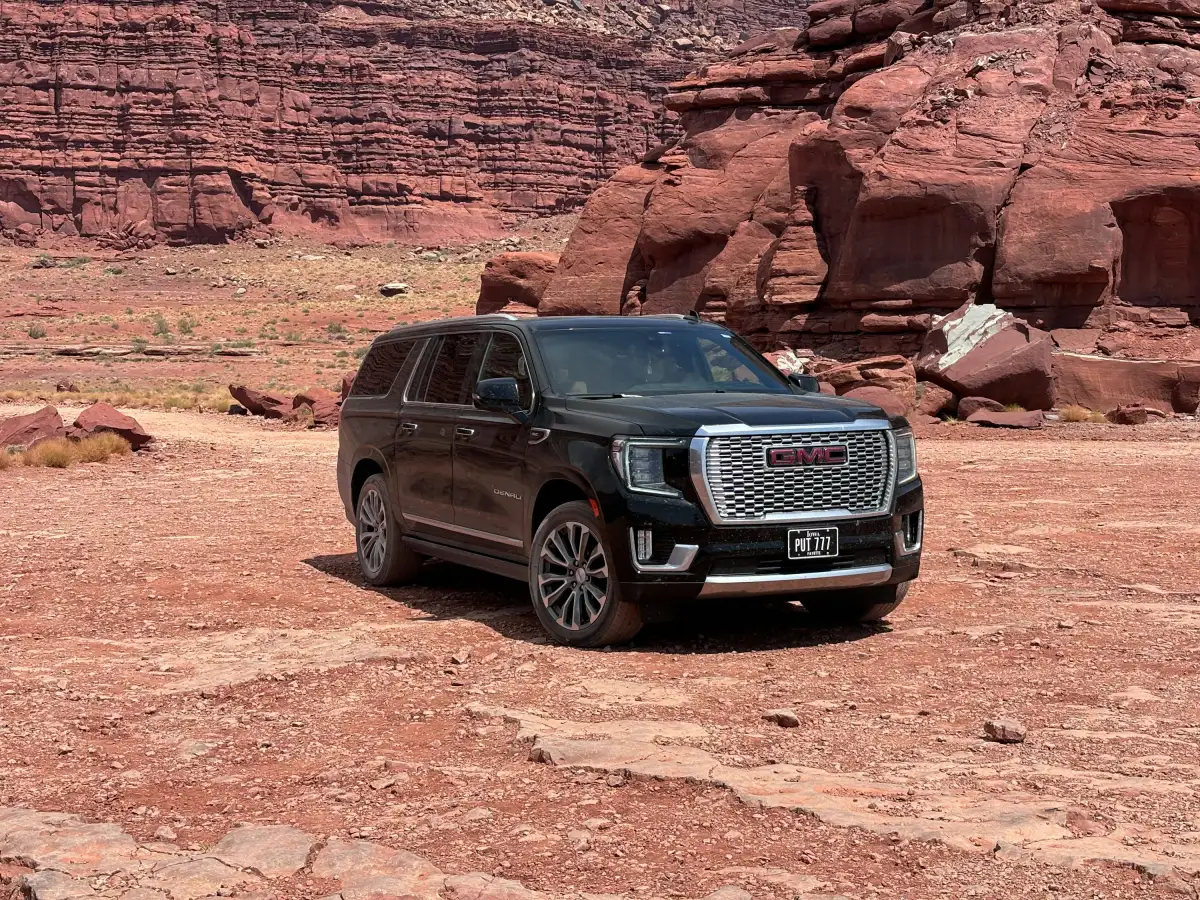 Black suv parked in a rocky desert landscape.